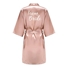 Load image into Gallery viewer, Bridesmaid in pink satin robe getting ready for wedding ceremony