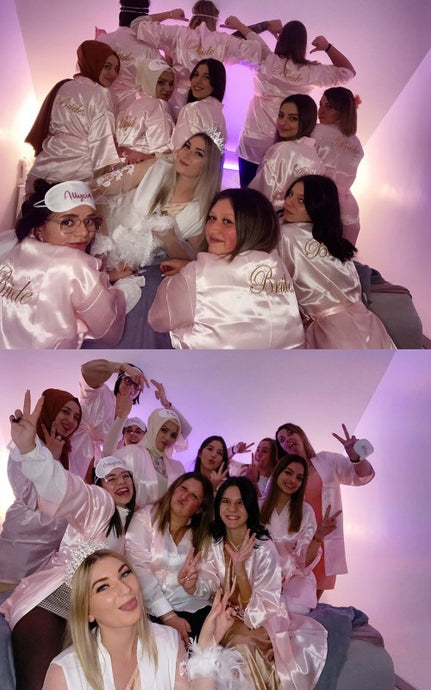 Bride wearing white satin robe with “Bride” embroidery before wedding